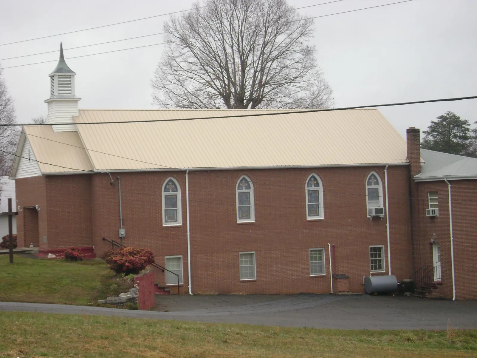 New tan metal roof on a brick church with a white steeple in Berkeley